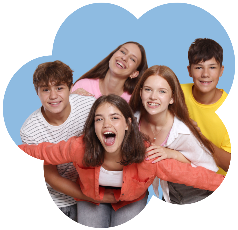 A group of five smiling teenagers with arms outstretched, laughing together
